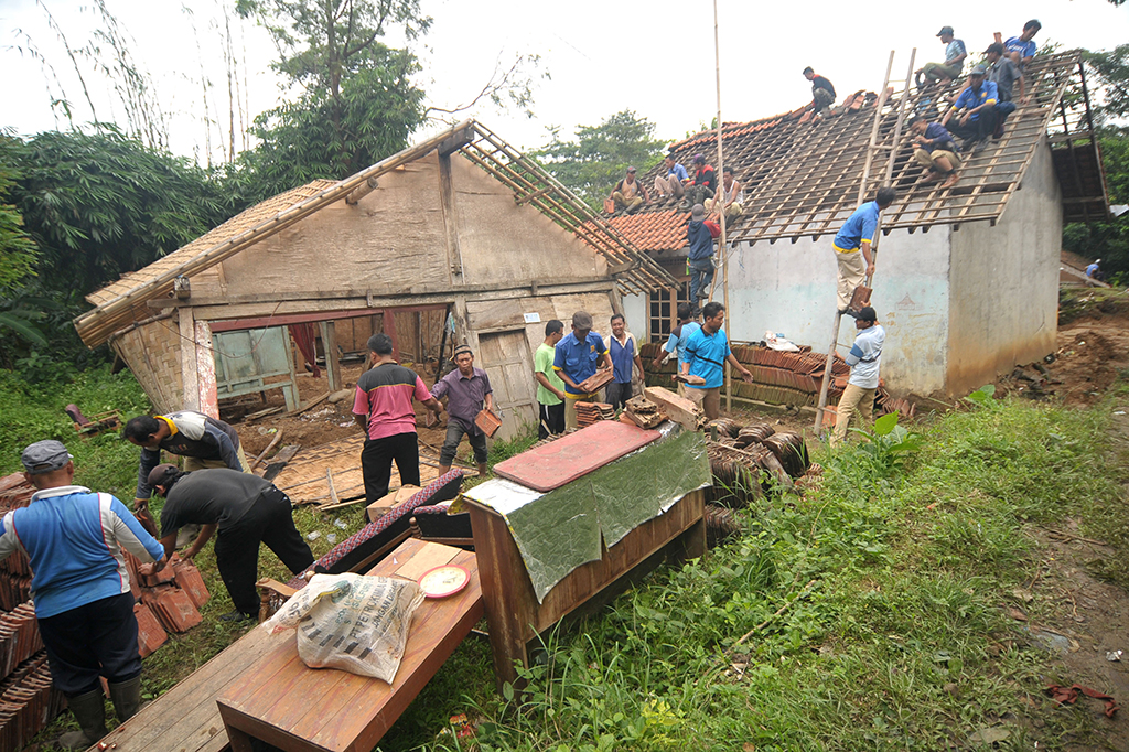 Sejumlah warga membersihkan puing-puing rumah yang rusak parah akibat terkena bencana tanah bergerak di Desa Dermasuci, Kabupaten Tegal, Jawa Tengah.