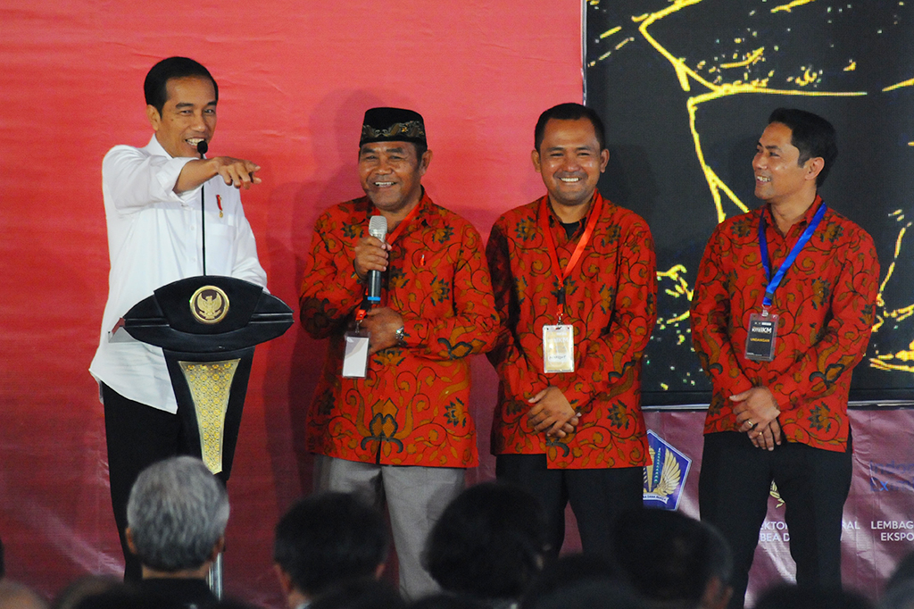 Presiden Joko Widodo (kiri) berbincang dengan pelaku industri kerajinan tembaga saat peluncuran fasilitas kebijakan Kemudahan Impor Tujuan Ekspor untuk Industri Kecil dan Menengah (KITE IKM).