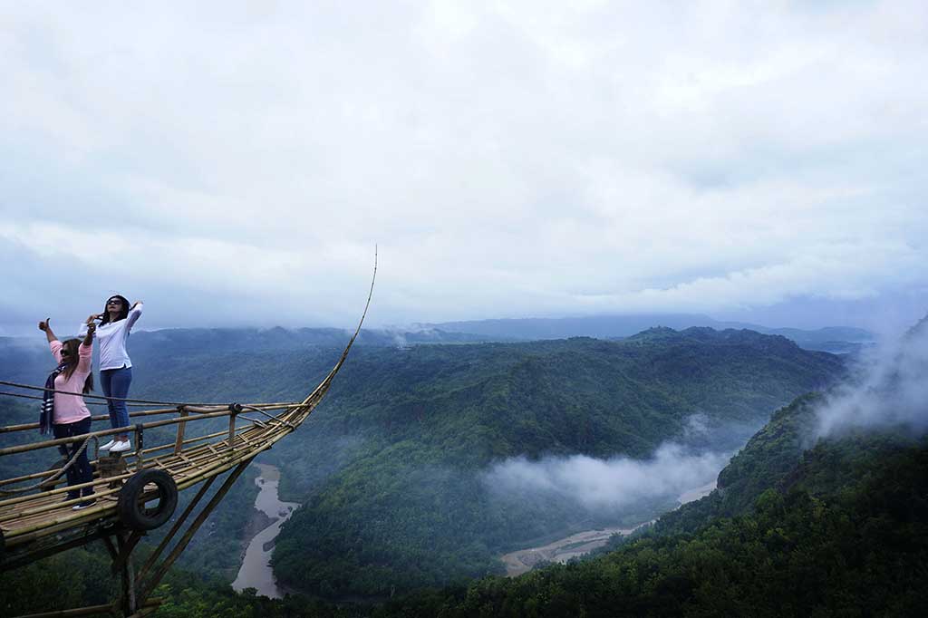 Pengunjung berswafoto di gardu pandang berbentuk perahu di Jurang Tembelan, Kanigoro, Dlingo, Bantul.
