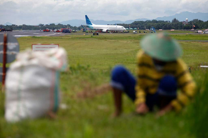 Petugas berusaha mengevakuasi badan pesawat Garuda Indonesia GA 258 ke landasan Bandara Adisutjipto, Sleman, Yogyakarta, Kamis.