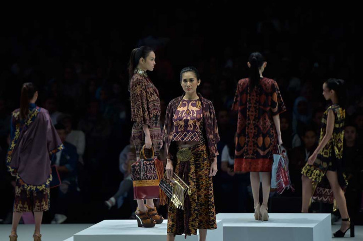 Model membawakan busana rancangan Yoyo Prasetyo dan aksesoris tas Warnatasku pada pertunjukan busana bertema Pesona Mutiara Maumere dalam rangkaian Indonesia Fashion Week.