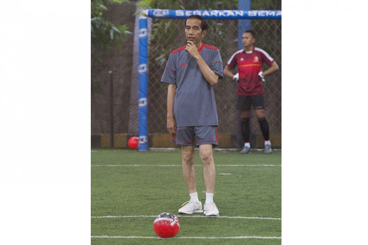 Presiden Joko Widodo bersiap menendang bola saat bermain futsal di Lapangan Futsal Time, Kelapa Gading, Jakarta.