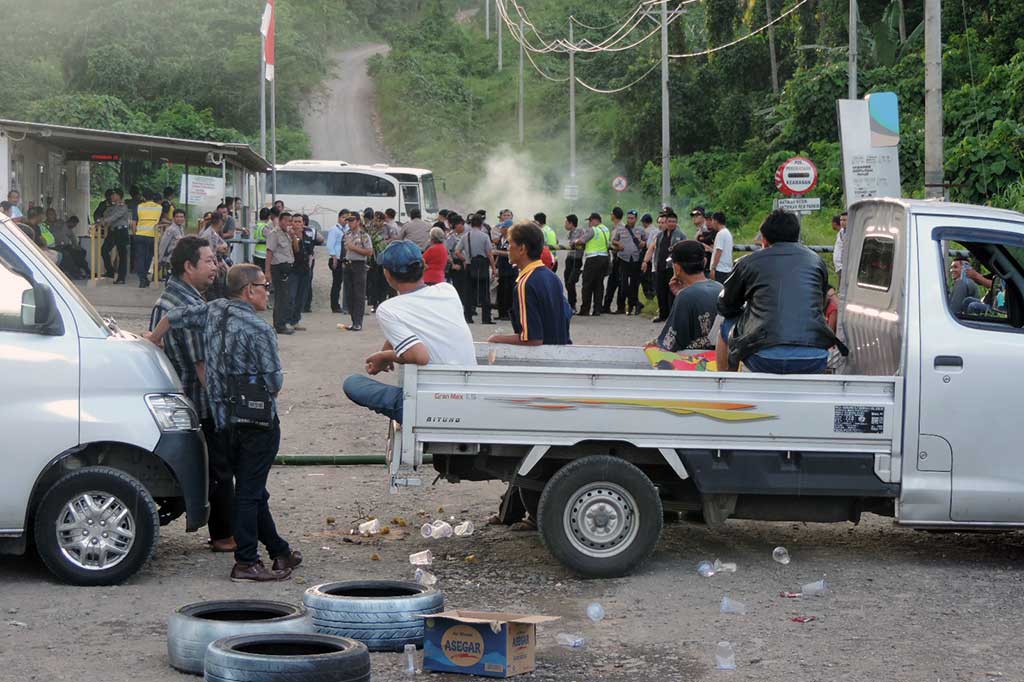 Warga yang mengklaim lahan seluas 20 Ha di kawasan kontrak karya PT Meares Soputan Mining (MSM), menutup akses jalan masuk perusahaan tersebut dengan dua mobil bak terbuka, Selasa (7/2/2017) .