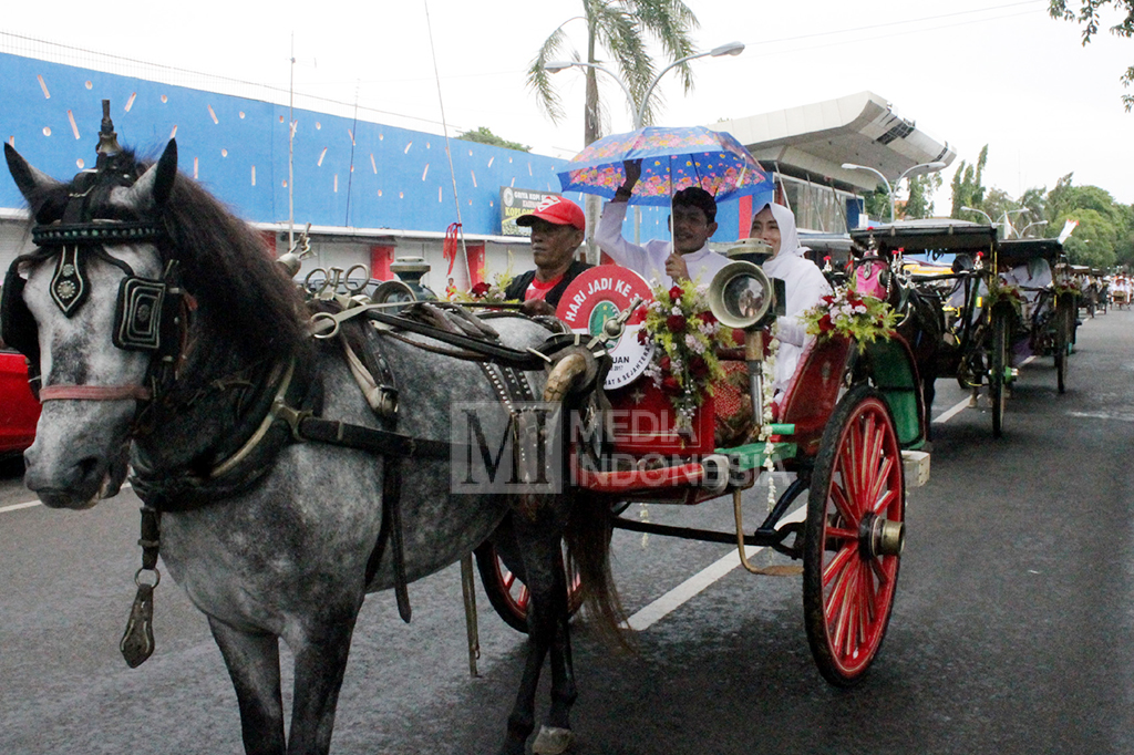 Para pejabat Pemkot Pasuruan menaiki kereta dalam kirab budaya pataka Untung Suropati menuju lokasi prosesi Hari jadi Kota Pasuruan ke-331 di GOR Sultan Agung.