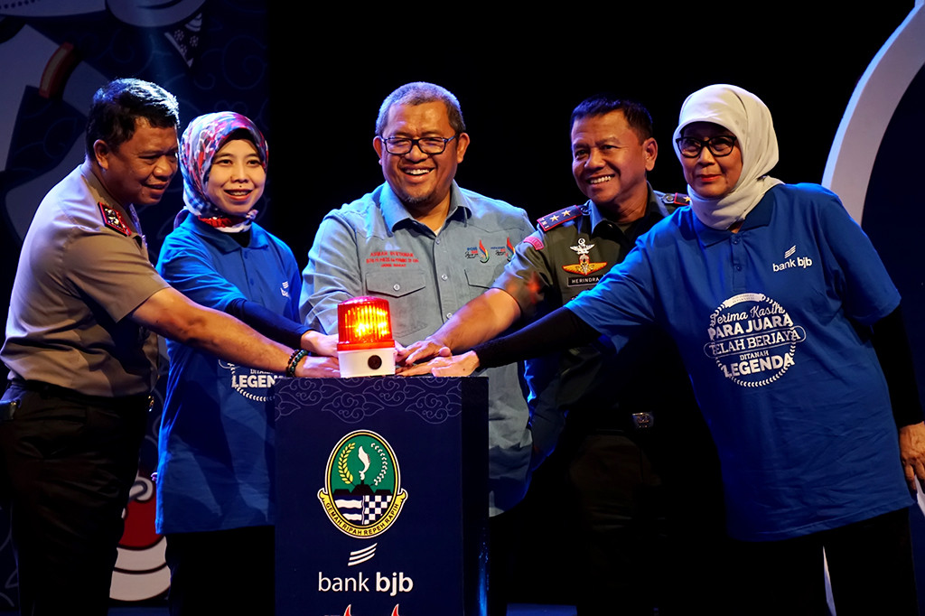 Gubernur Jabar Ahmad Heryawan (tengah) menekan tombol secara simbolis Pemberian Penghargaan Bagi Kontingen Jabar pada PON XIX dan Peparnas XV di Gedung Sabuga, Bandung, Jawa Barat.