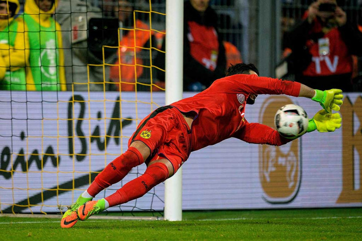 Kiper Borussia Dortmund Roman Buerki menggagalkan tendangan penalti pemain Bertha Berlin.