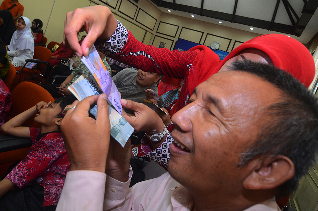 Penyandang tunanetra meraba uang rupiah tahun emisi 2016.