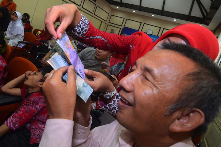 Penyandang tunanetra meraba uang rupiah tahun emisi 2016.