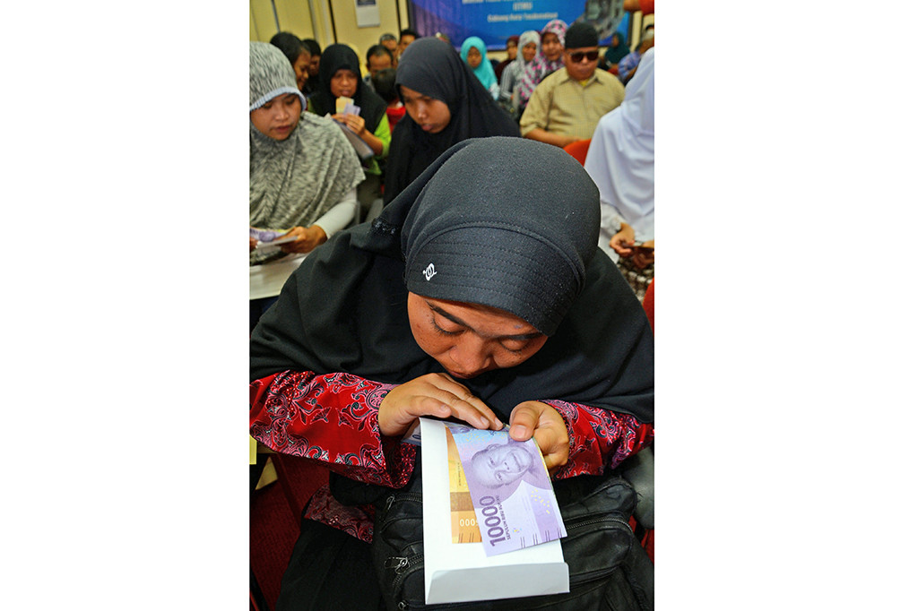 Penyandang tunanetra meraba uang rupiah tahun emisi 2016.