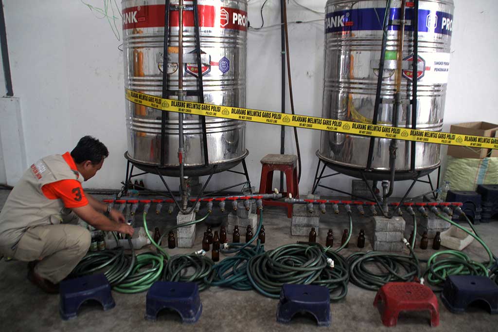Anggota Ditreskrimsus Polda Jatim menunjukkan barang bukti alat produksi jamu ilegal di pergudangan kawasan Bypass Krian, Balongbendo, Sidoarjo.