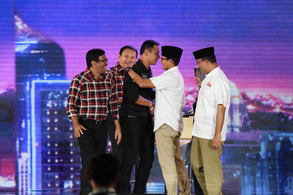 Usai debat yang berlangsung panas, tiga pasangan calon saling bertukar salam dan senyum.