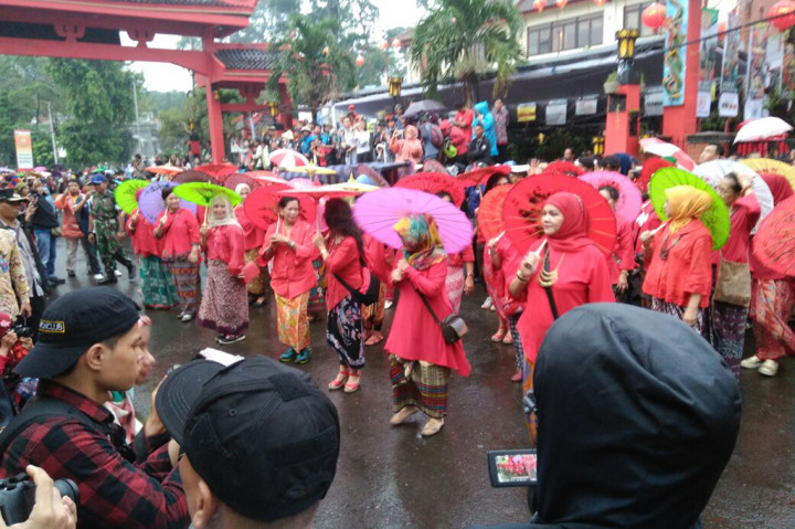 Warga tak beranjak dari tempat mereka meski hujan mengguyur sepanjang acara yang digelar untuk ke-15 kalinya tersebut.
