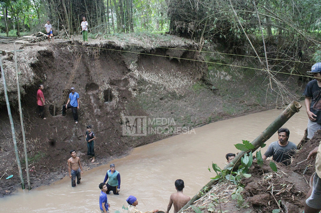 Warga dari Desa Kalipang dan Gratitunon, Kecamatan Grati, Kabupaten Pasuruan, bergotong royong secara swadaya, membangun jembatan darurat.