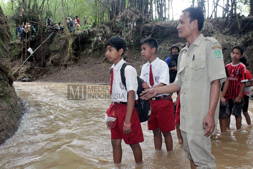 Akibatnya, sejumlah pelajar dan guru terpaksa menyeberangi sungai saat berangkat dan pulang sekolah.