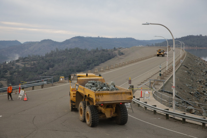 Truk membawa pecahan batu-batu besar menuju titik rawan banjir akibat rusaknya pintu air. 