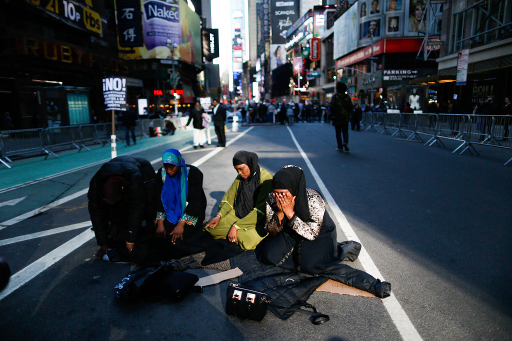 Tiga orang muslimah melaksanakan sholat Ashar di badan jalan Times Square yang ditutup sebagian. Eduardo Munoz Alvarez/Getty Images/AFP