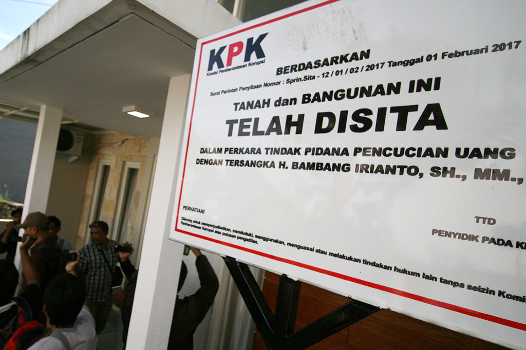 Petugas KPK memasang papan penyitaan aset Wali Kota Madiun nonaktif Bambang Irianto di perumahan Greenland, Kediri, Jawa Timur.