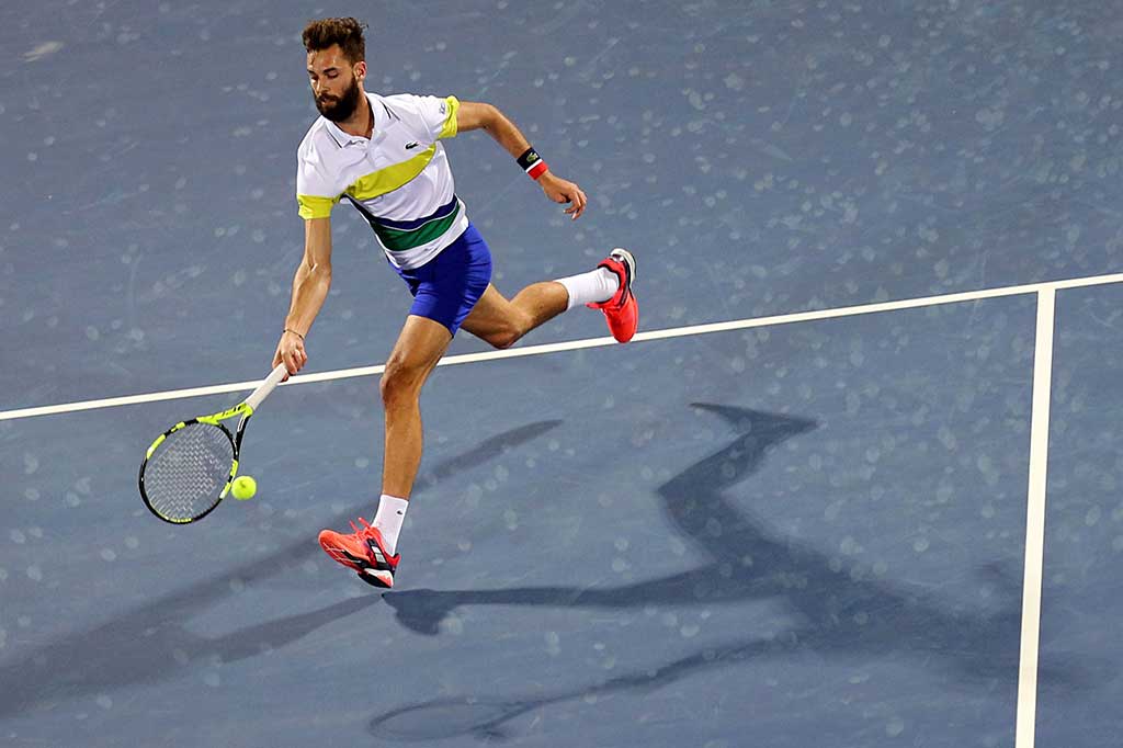 Paire berusaha mengembalikan bola ke arah Federer.