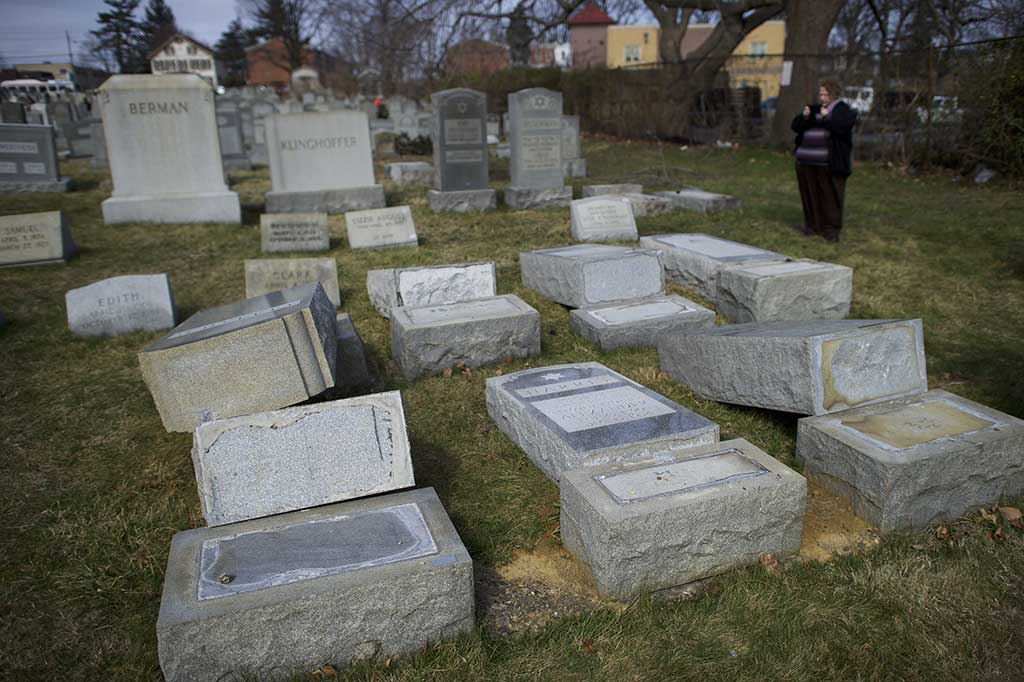 Seorang perempuan mengambil gambar batu nisan yang dirusak di pemakaman Yahudi Mount Carmel, Philadelphia, Pennsylvania, Senin (27/2/2017) waktu setempat.