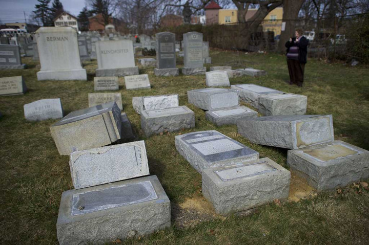 Seorang perempuan mengambil gambar batu nisan yang dirusak di pemakaman Yahudi Mount Carmel, Philadelphia, Pennsylvania, Senin (27/2/2017) waktu setempat.