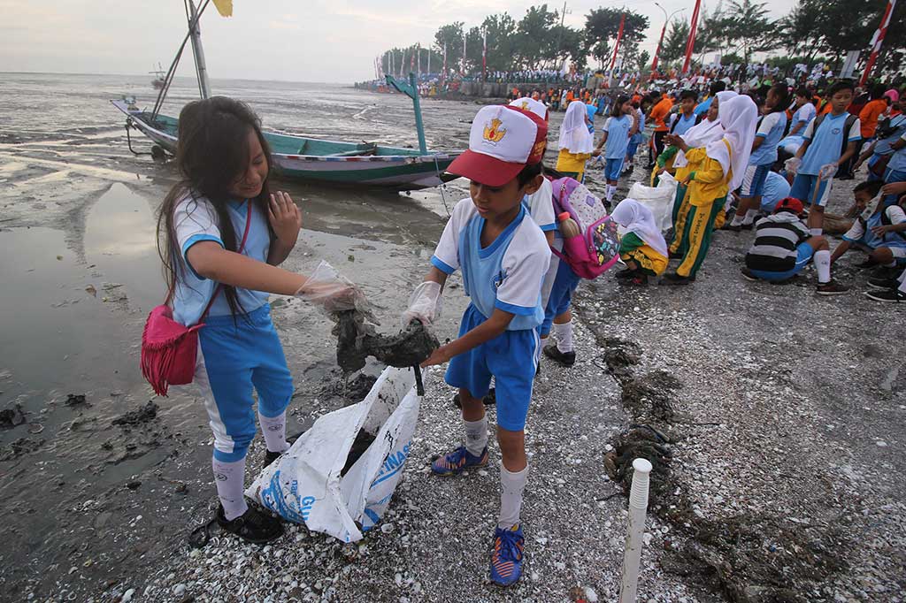 Pelajar memungut sampah yang berserakan di sepanjang Pantai Kenjeran, Surabaya, Jawa Timur, Selasa (28/2/2017). 