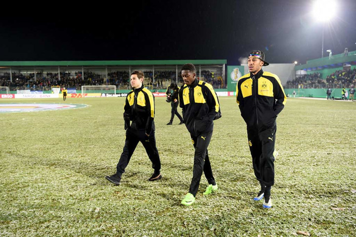 Para pemain Borrusia Dortmund (dari kiri) Raphael Guerreiro, Ousmane Dembele, dan Pierre-Emerick Aubameyang berjalan meninggalkan lapangan.