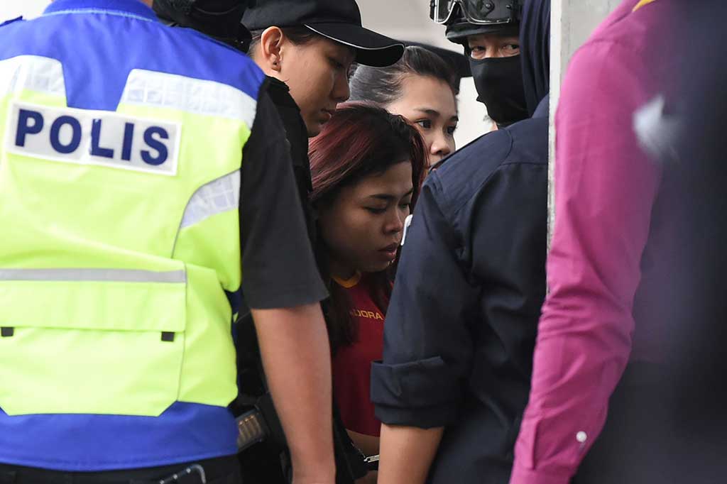 Warga Indonesia Siti Aisyah dengan pengawalan ketat tiba di sebuah gedung pengadilan di Sepang, Malaysia.