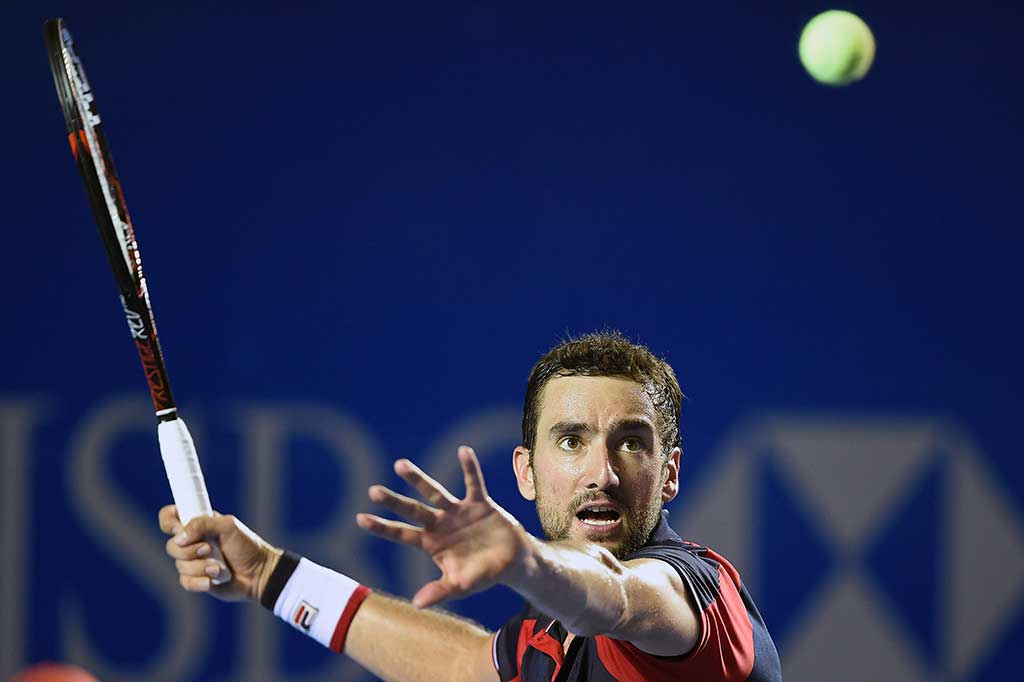 Cilic berusaha mengembalikan bola ke arah Nadal.