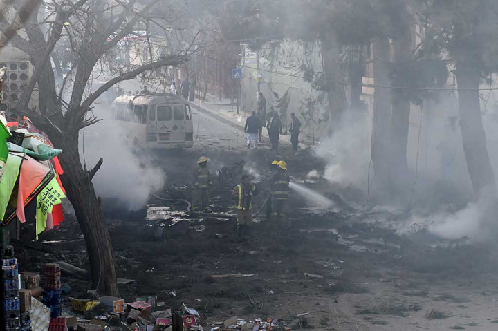 Petugas pemadam kebakaran memadamkan sisa-sisa api pascaledakan bom bunuh diri di Kabul, Afghanistan, Senin (13/3/2017).