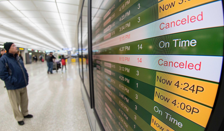 Papan jadwal di Dulles International Airport, Virginia, Washington DC menunjukkan banyak penerbangan yang terpaksa dibatalkan akibat serangan badai salju. AFP PHOTO / Paul J. Richards