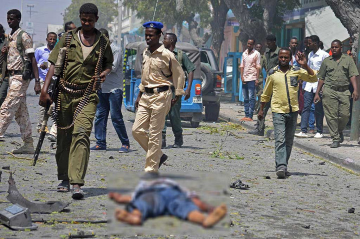 Petugas keamanan berjalan di dekat jenazah korban ledakan bom di Mogadishu, Senin. 