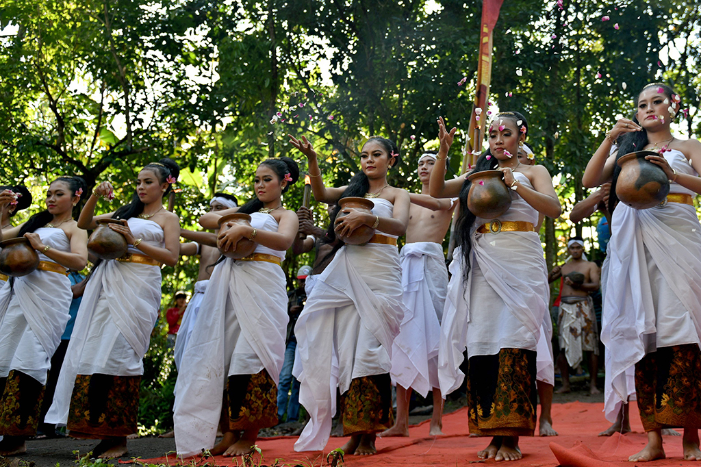 Peserta kirab melempar kembang saat mengikuti prosesi Gelar Budaya Nyadran Kali.