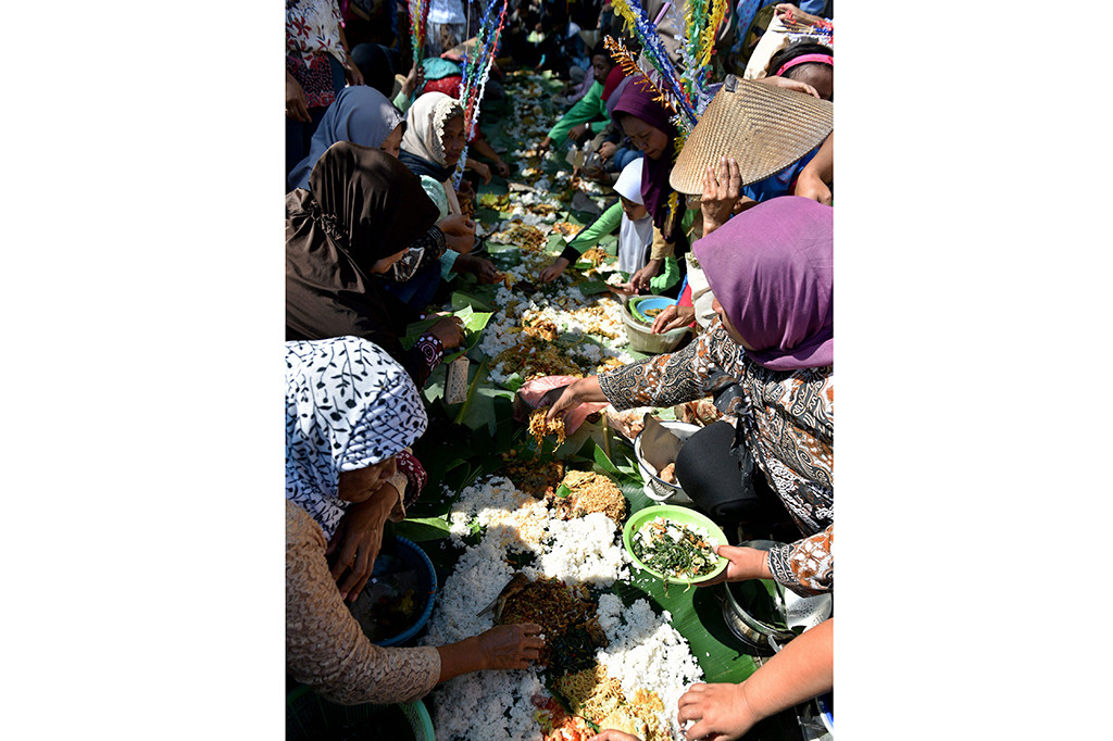 Warga makan bersama usai mengikuti prosesi Gelar Budaya Nyadran Kali di Desa Wisata Kandri, Semarang, Jawa Tengah.