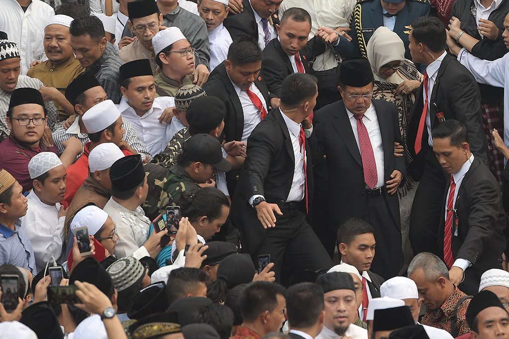 Wakil Presiden Jusuf Kalla (kedua kanan) berjalan usai mensalatkan jenazah KH Hasyim Muzadi di Masjid Al-Hikam.  