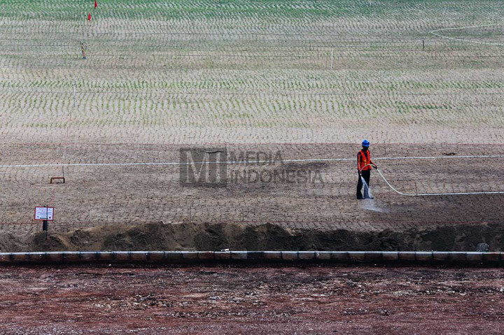 Pekerja menyirami rumput stadion pada  proyek renovasi Stadion Utama Gelora Bung Karno (SUGBK).