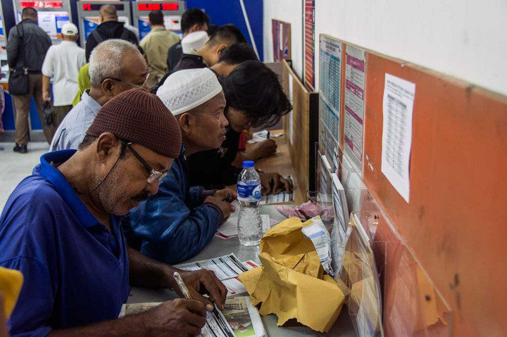 Calon penumpang mengisi formulir pemesanan tiket kereta api di Stastiun Pasar Senen, Jakarta.