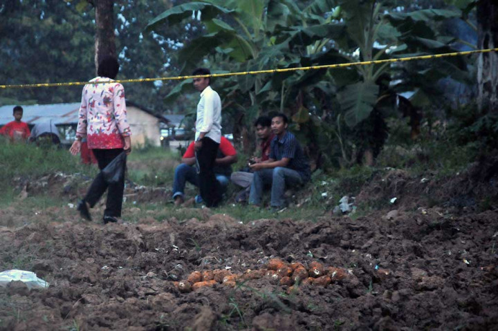 Anggota kepolisian berpakaian preman menjaga granat nanas aktif yang ditemukan warga di areal persawahan Desa Slawi Wetan, Kabupaten Tegal, Jawa Tengah, Jumat (17/3/2017).