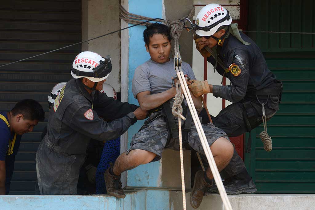 Polisi dan petugas pemadam kebakaran mengevakuasi warga dari kediamannya yang terendam banjir di Distrik Huachipa, Lima, Peru, Jumat (17/3/2017) waktu setempat.