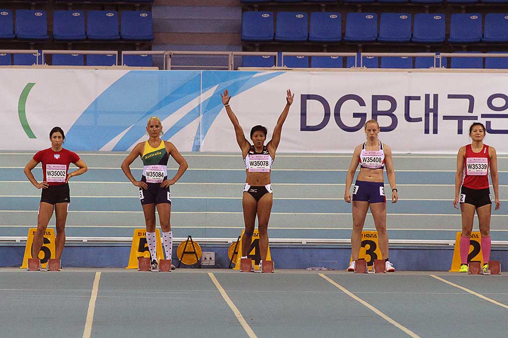 Pelari putri Indonesia Dedeh Erawati (tengah) mengangkat tangan sebelum bertanding nomor lari 60 meter putri kategori usia 35-39 tahun dalam kejuaraan World Masters Athletics Championships indoor (WMACI) di Daegu, Korea Selatan, Selasa (21/3/2017).