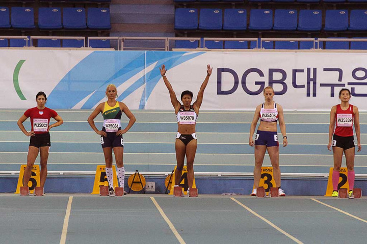 Pelari putri Indonesia Dedeh Erawati (tengah) mengangkat tangan sebelum bertanding nomor lari 60 meter putri kategori usia 35-39 tahun dalam kejuaraan World Masters Athletics Championships indoor (WMACI) di Daegu, Korea Selatan, Selasa (21/3/2017).
