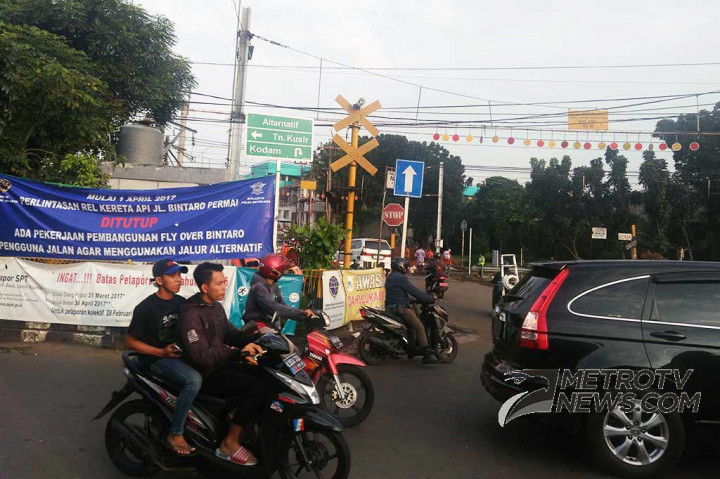 Pengendara melintasi spanduk yang berisi pengumuman rencana penutupan perlintasan kereta api Bintaro Pesanggrahan pada 1 April mendatang, di Jalan Bintaro Permai, Jakarta Selatan, Jumat (24/3/2017). MTVN/Wijokongko