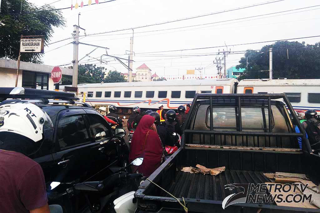 Pengendara berhenti di perlintasan kereta api Bintaro Pesanggarahan, Bintaro, Jakarta Selatan, Jumat (24/3/2017). MTVN/Wijokongko