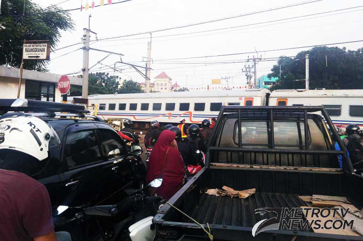 Pengendara berhenti di perlintasan kereta api Bintaro Pesanggarahan, Bintaro, Jakarta Selatan, Jumat (24/3/2017). MTVN/Wijokongko