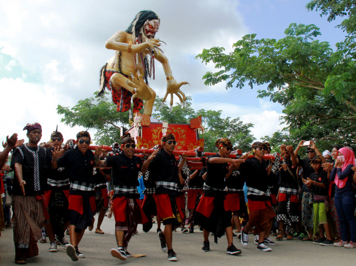 Warga menonton arak-arakan ogoh - ogoh yang melintas di depan Kantor Bupati Mamuju Tengah, Sulawesi Barat, Minggu (26/3/2017). Ritual pawai ogoh - ogoh kini sudah menjadi atraksi hiburan tersendiri bagi warga. ANTARA FOTO/Akbar Tado