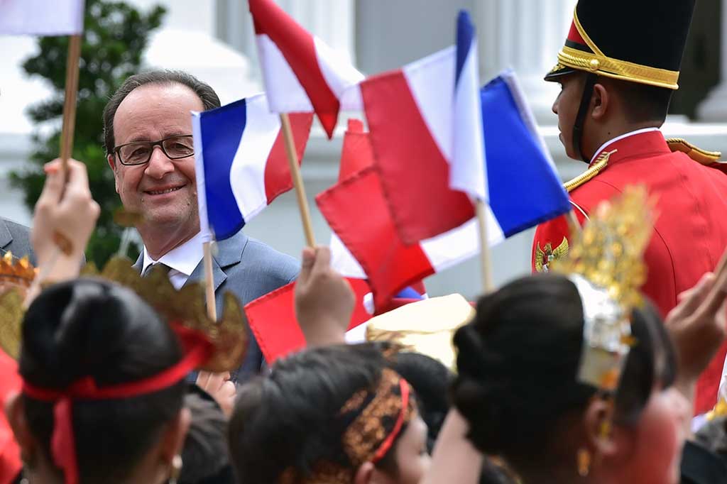 Presiden Hollande tersenyum saat melihat anak-anak SD yang memakai baju adat dari berbagai daerah Indonesia mengibarkan bendera Sang Saka Merah Putih dan Bendera Prancis.
