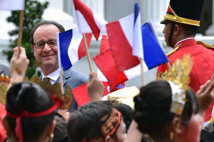 Presiden Hollande tersenyum saat melihat anak-anak SD yang memakai baju adat dari berbagai daerah Indonesia mengibarkan bendera Sang Saka Merah Putih dan Bendera Prancis.
