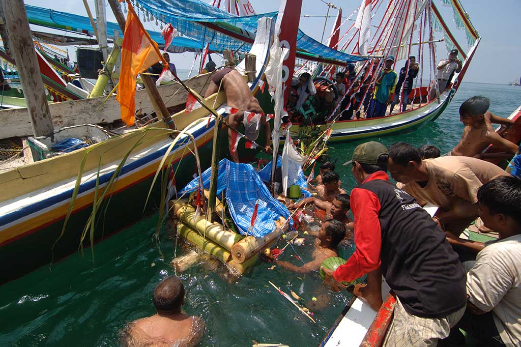 Nelayan melarung sesaji dalam ritual 'Petik Laut'. 