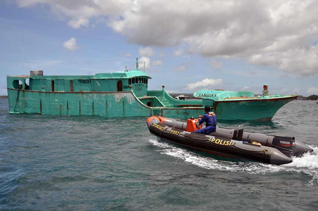 Petugas memantau proses penenggelaman kapal pelaku 'illegal fishing' yang dilubangi dan diberi pemberat di perairan Tanjung Benoa, Badung, Bali. ANTARA/Fikri Yusuf