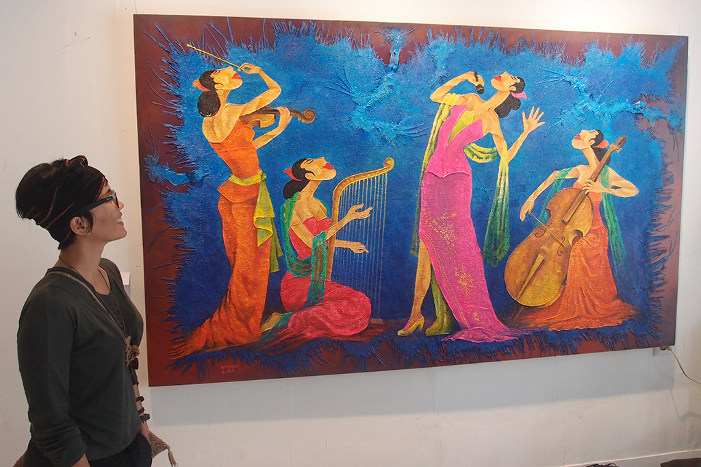 Seorang pengunjung mengamati sebuah lukisan berjudul 