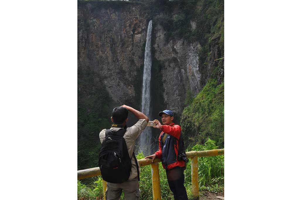 Pengunjung menikmati keindahan air terjun Sipiso-Piso.